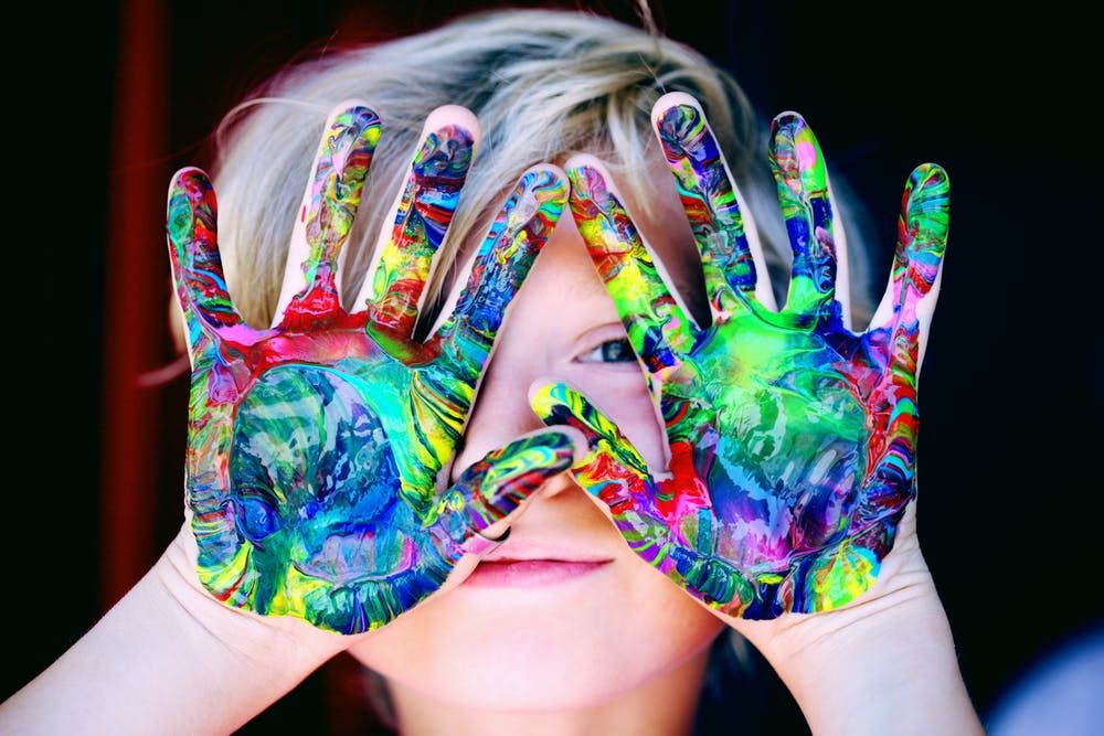 boy with painted palms up to his face